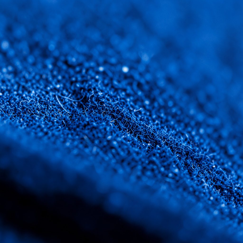 Detalle macro de partículas y burbujas en agua industrial con luz difusa en tonos gris azulado, evocando filtración y tratamiento.