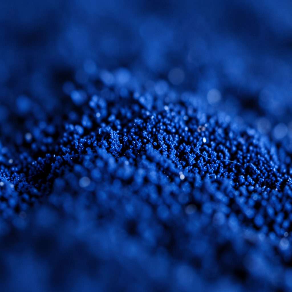 Primer plano extremo de una superficie industrial gris azulada con líneas finas y textura uniforme, evocando una instalación técnica sobria.