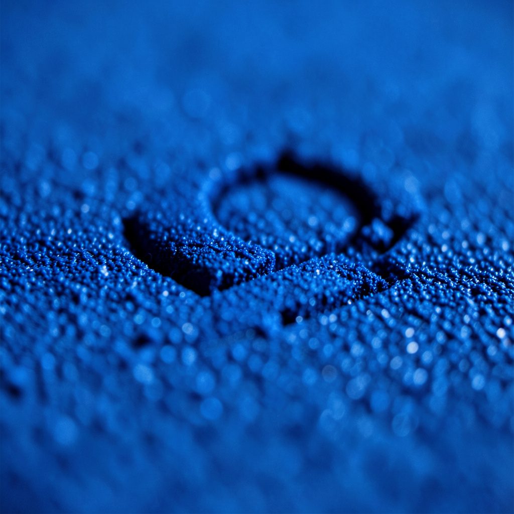Primer plano extremo de una superficie metálica azul marino con vetas sutiles y reflejo apagado, evocando un tono industrial limpio y profesional.